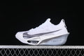 Side view of a white Nike racing shoe with a large grey Swoosh and sculpted sole
