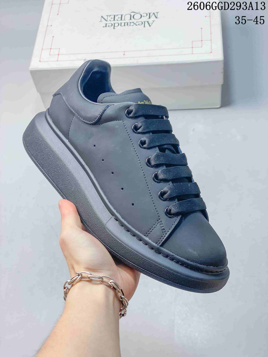 Angled side view of a dark charcoal low-top sneaker with a padded collar and tonal sole.