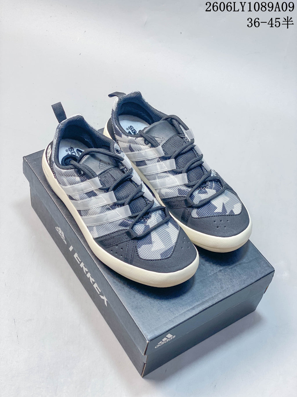 Pair of gray graphic Adidas Climacool shoes with blue and teal accents, pictured on a Terrex box.