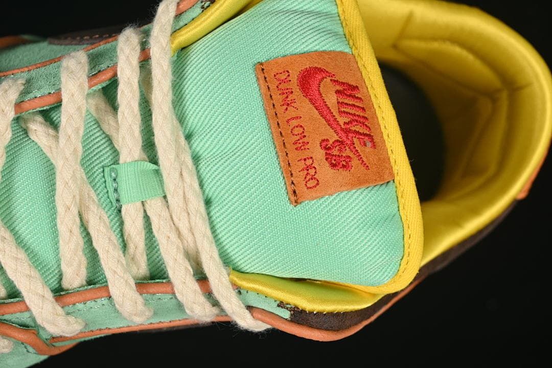 Close-up of the tongue patch, cream-colored laces, and yellow collar lining.