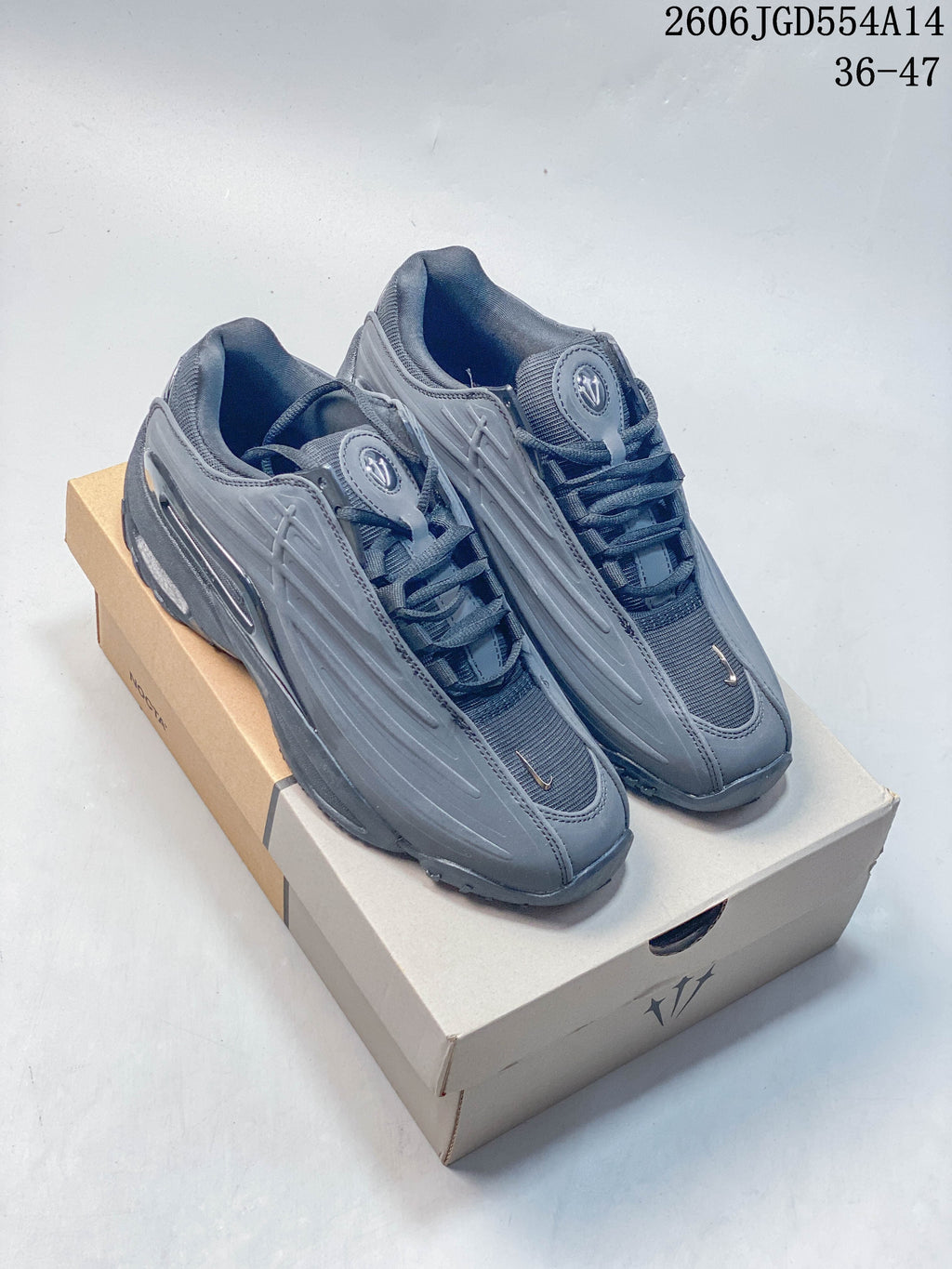 Pair of dark gray Nike NOCTA Hot Step 2 low-top sneakers on a box