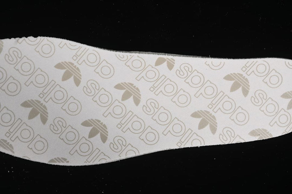 Close-up of an insole printed with adidas wordmarks and trefoil logos