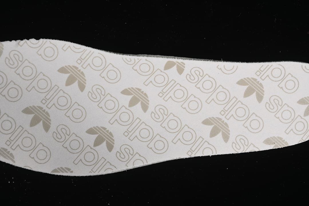 Close-up of an insole printed with adidas wordmarks and trefoil logos