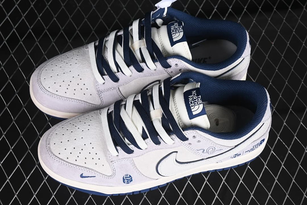 Pair of gray and white low-top sneakers with navy laces and accents.