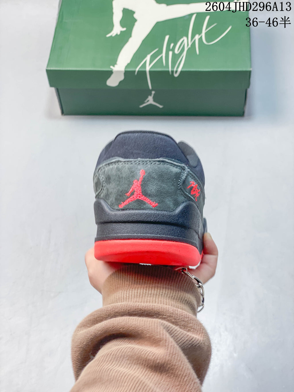 Rear view showing a gray heel panel, red logo detail, and red outsole.