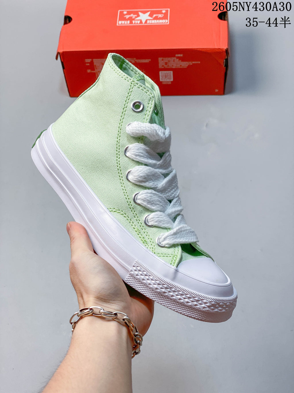 Angled side view of a pale mint green high-top sneaker