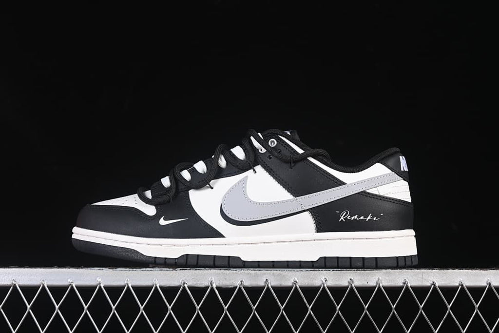 Side view of a black-and-white Nike SB Dunk Low sneaker with a light gray Swoosh.