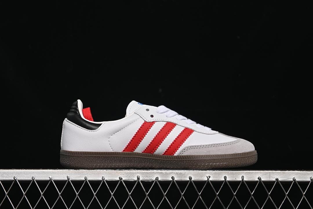 Side profile of the white sneaker with red stripes and dark outsole