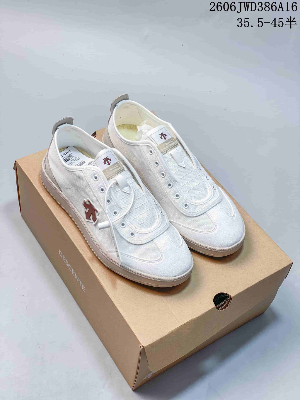 White DESCENTE Chron Pacer CVS sneakers shown from above on a branded box
