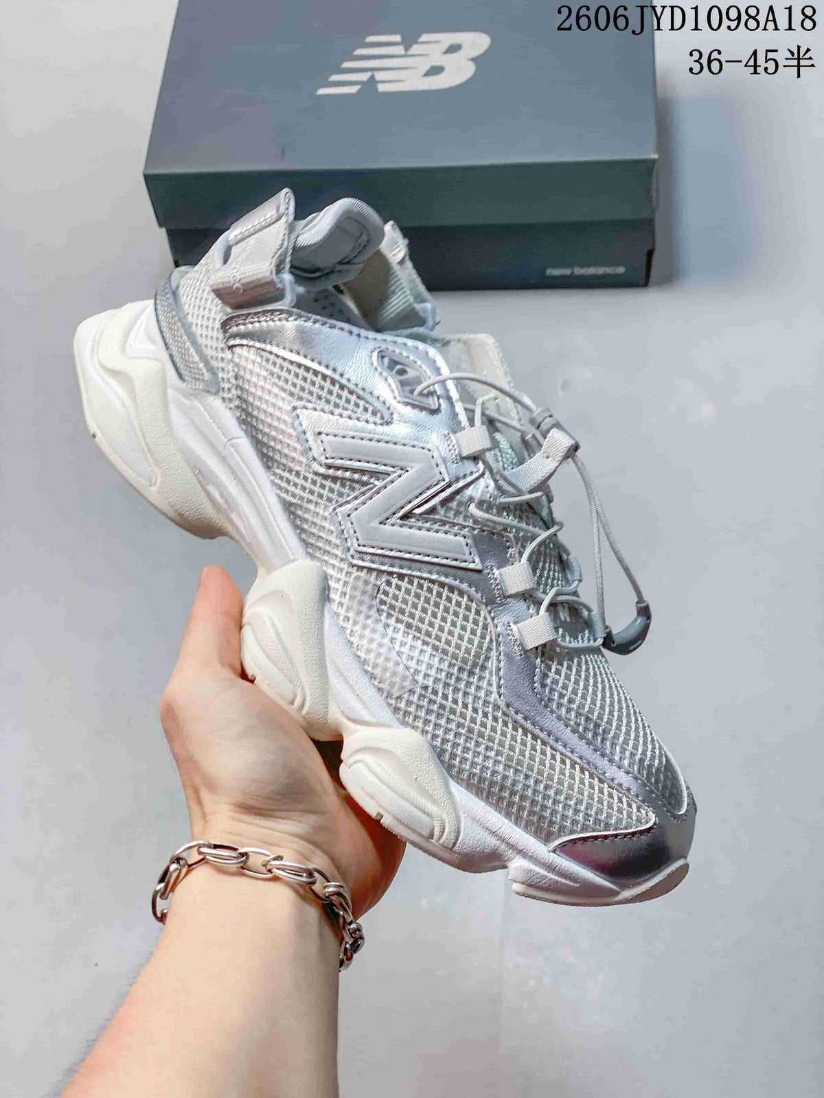 Angled side view of the silver-toned sneaker with its sculpted sole.