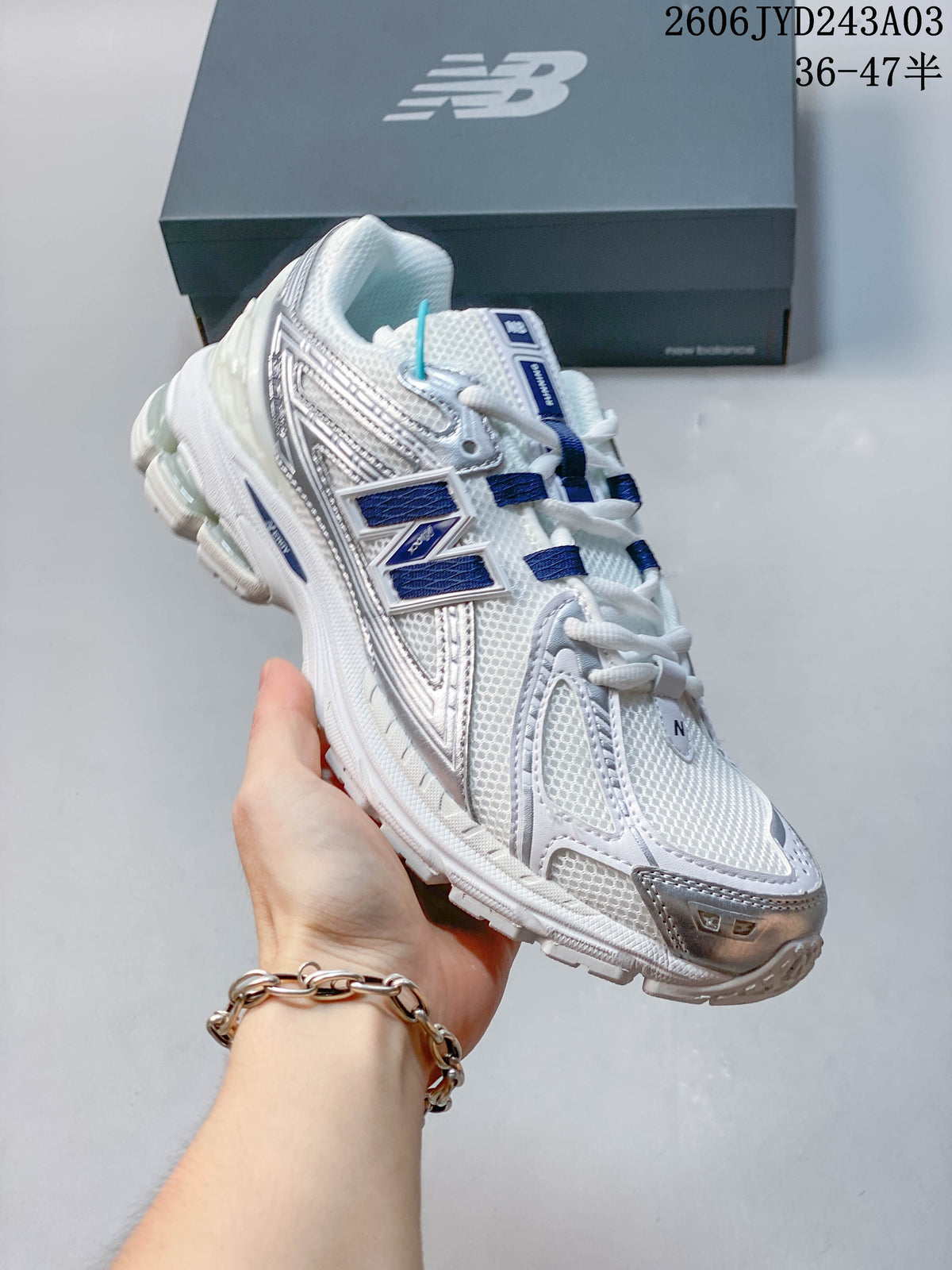 Angled side view of a white and silver New Balance sneaker