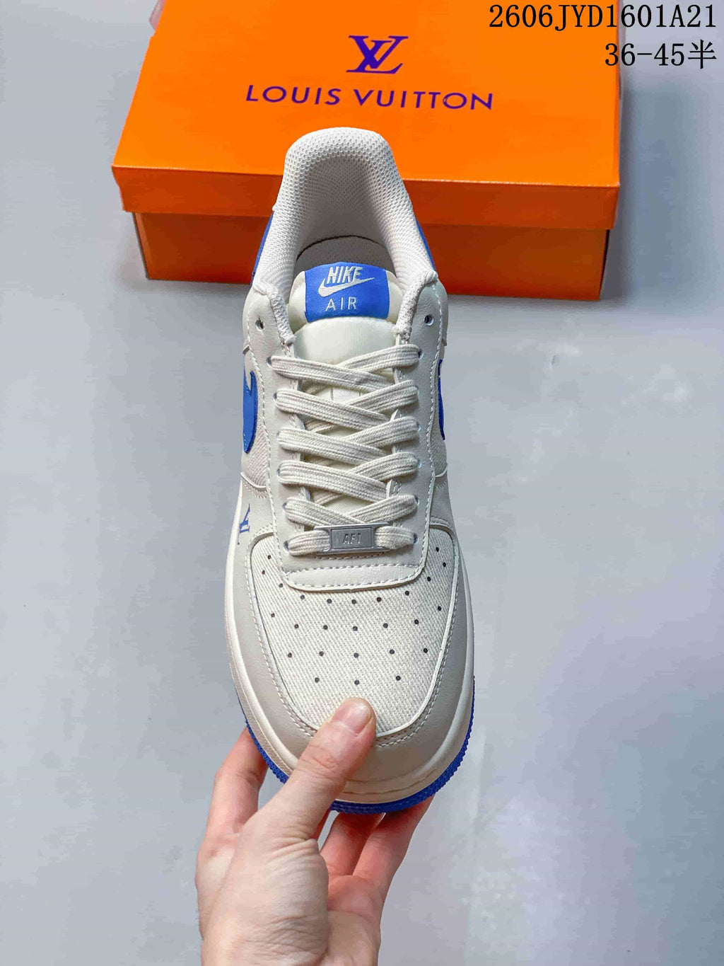 Top view of a white sneaker showing the perforated toe and blue tongue label