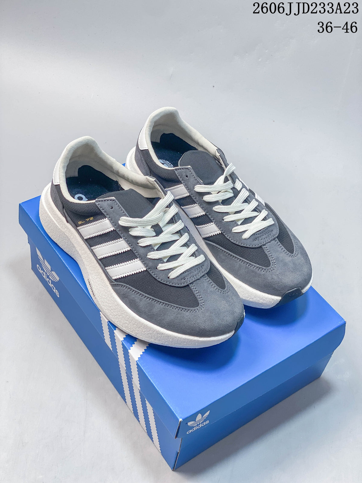 Pair of gray and white adidas Originals SL 72 Pro sneakers on a blue shoe box