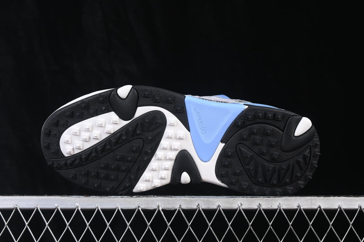 Underside view of the sneakers showing the patterned black and white outsole