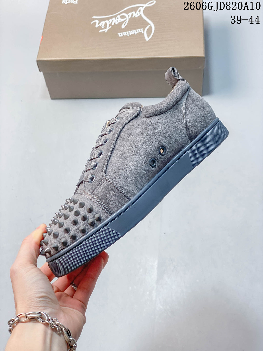 Side view of a grey studded low-top sneaker