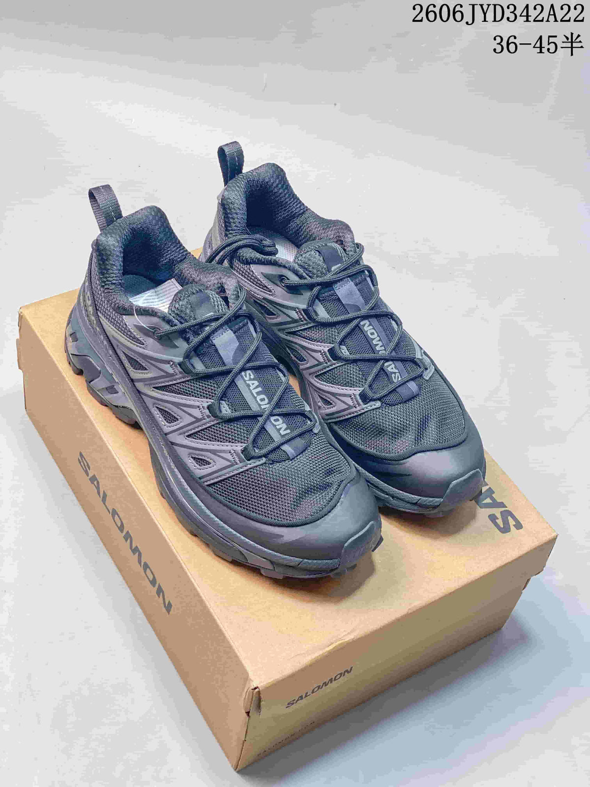 Pair of dark gray Salomon mesh sneakers on a shoe box