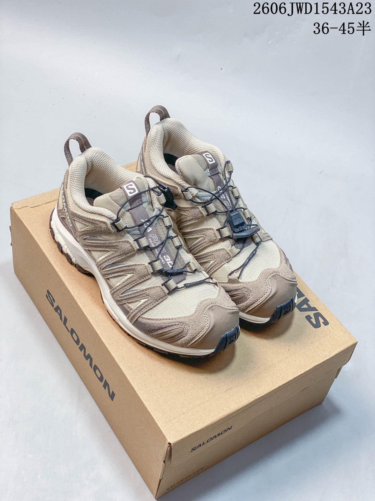 Pair of beige Salomon XA Pro 3D shoes on a Salomon box