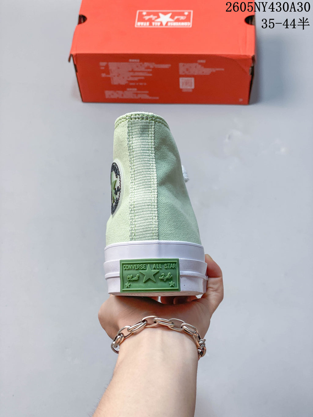 Rear view of a mint green high-top sneaker with a green heel patch