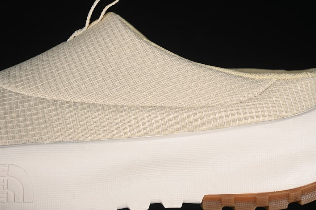 Close-up of the patterned upper, white midsole, and brown outsole.