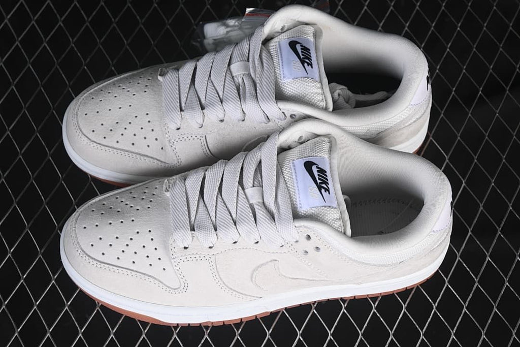 Pair of light-colored Nike SB Dunk Low sneakers viewed from above