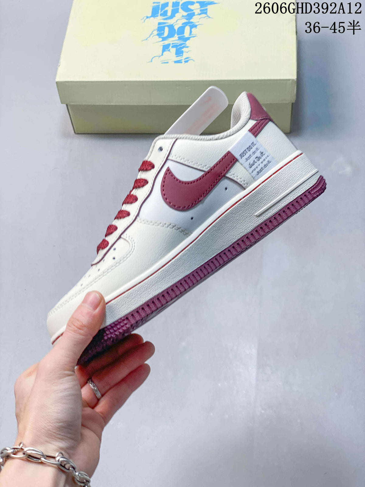Side view of the sneaker with burgundy Swoosh and trim
