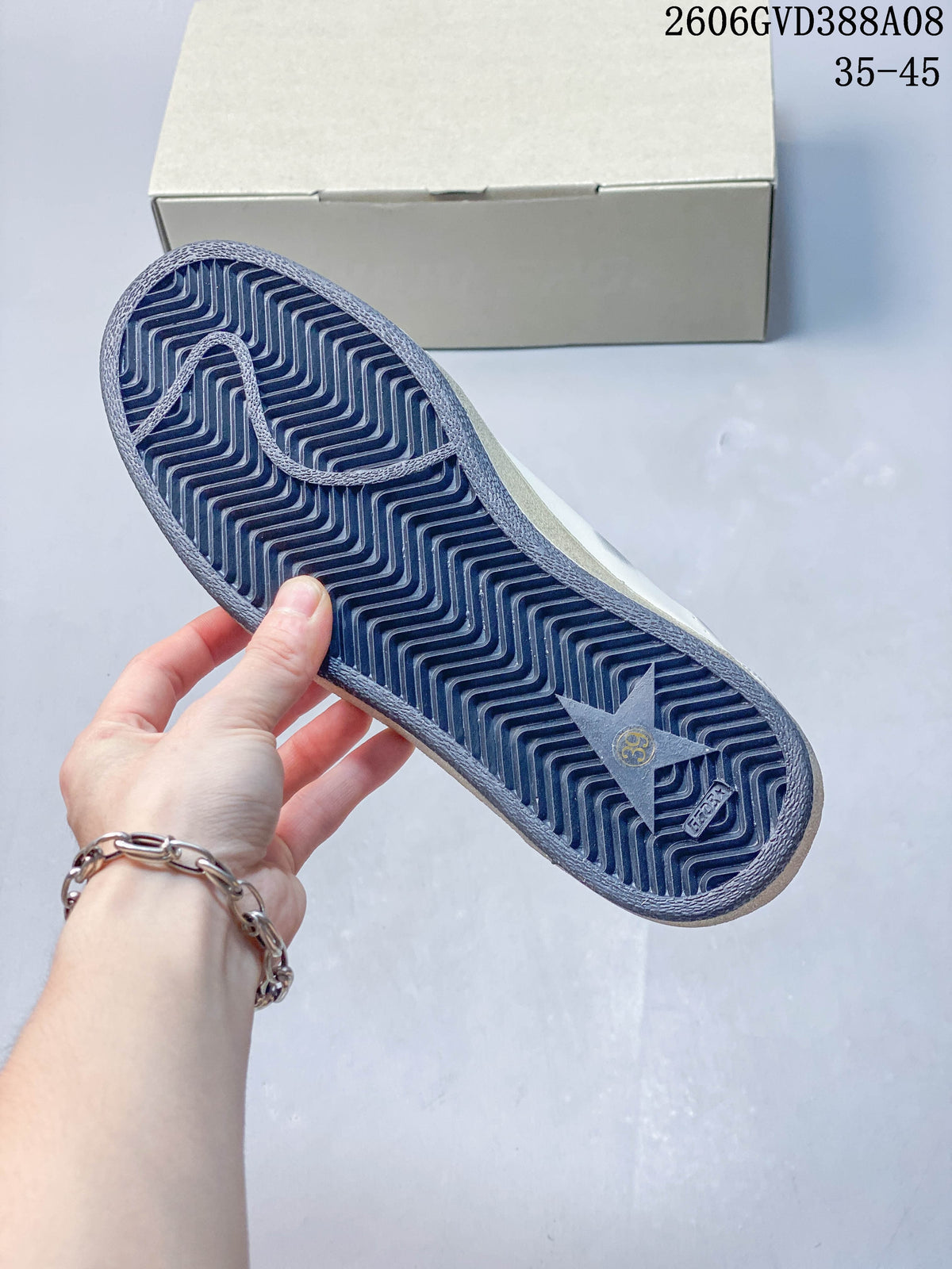 Underside of sneaker showing a dark patterned outsole