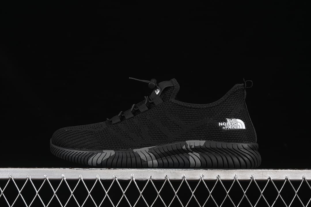 Side view of a black The North Face sneaker with a sculpted sole