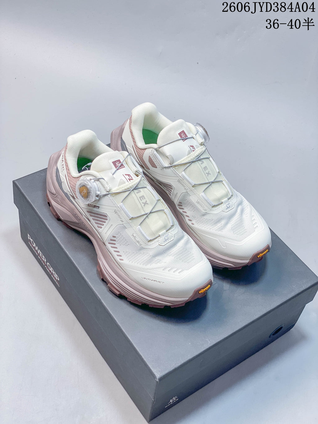Pair of off-white and muted rose Kailas FUGA EX3 BOA hiking shoes shown on a shoe box