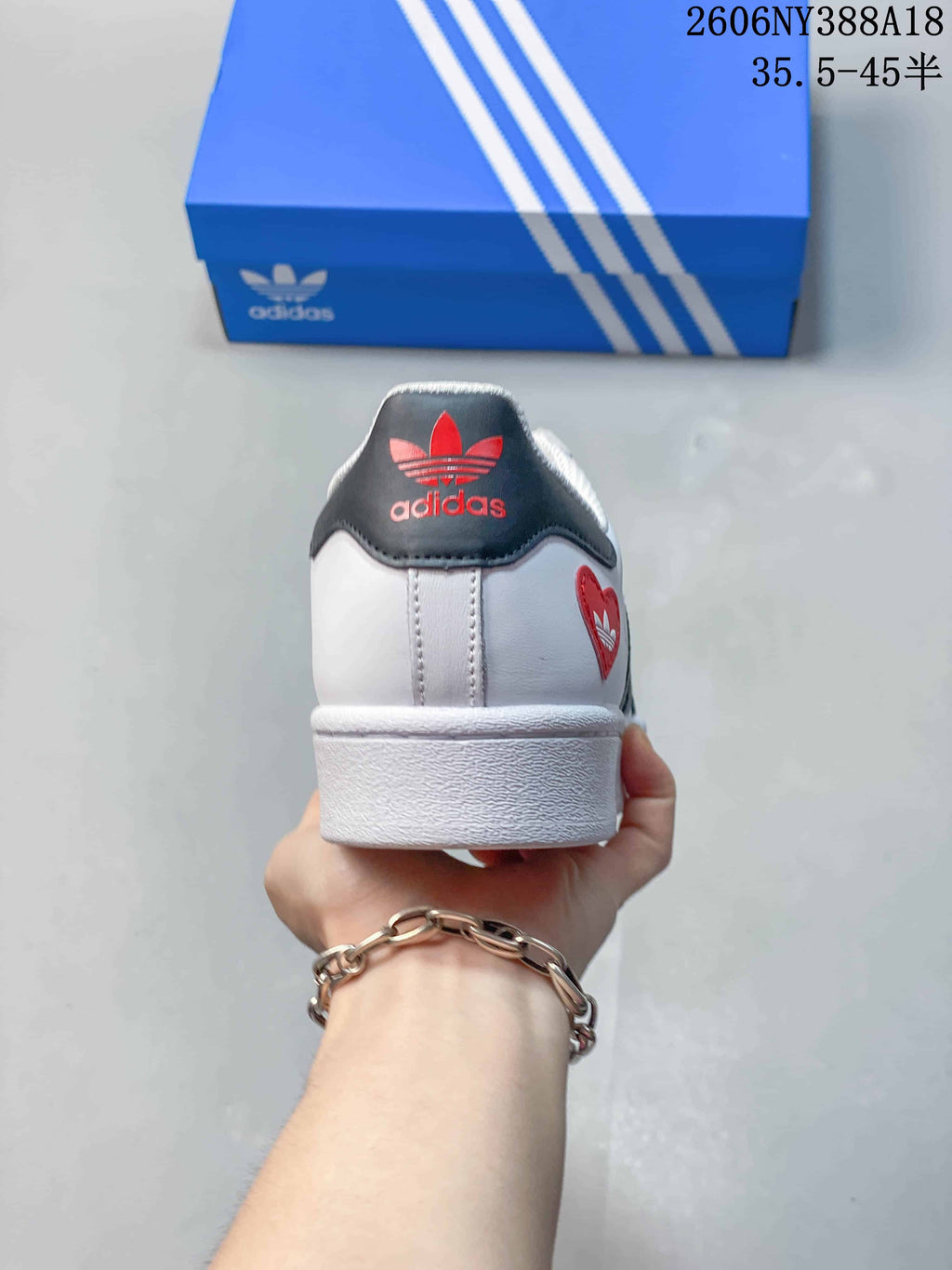 Rear view of the Superstar sneaker with a dark heel panel and red logo details
