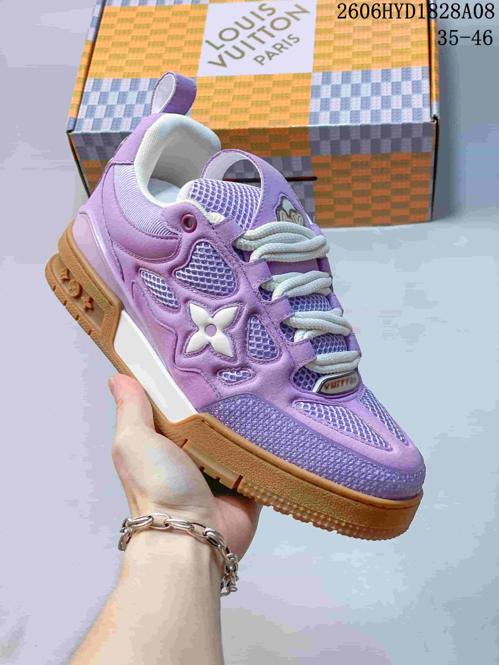 Angled side view of a lavender Trainer-style sneaker with decorative side detailing