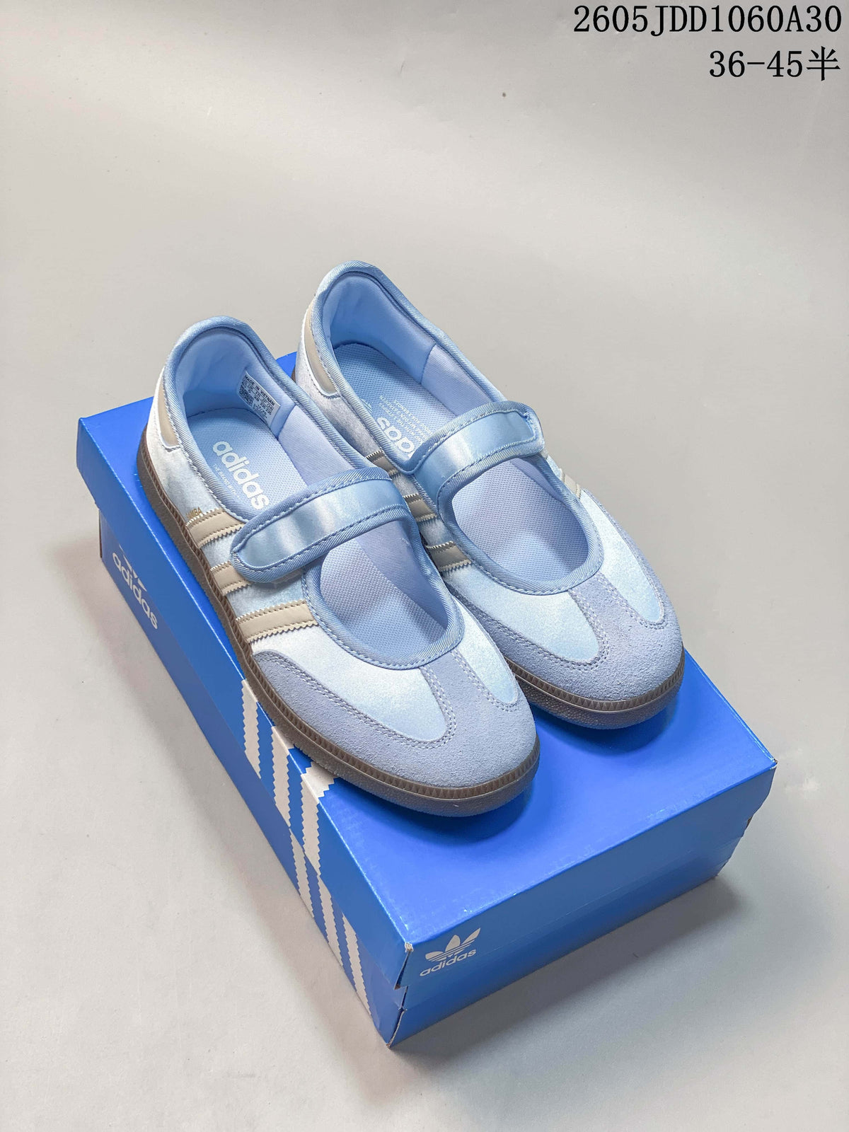 Pair of pale blue Adidas Samba Jane-style sneakers with hook-and-loop straps and brown outsoles