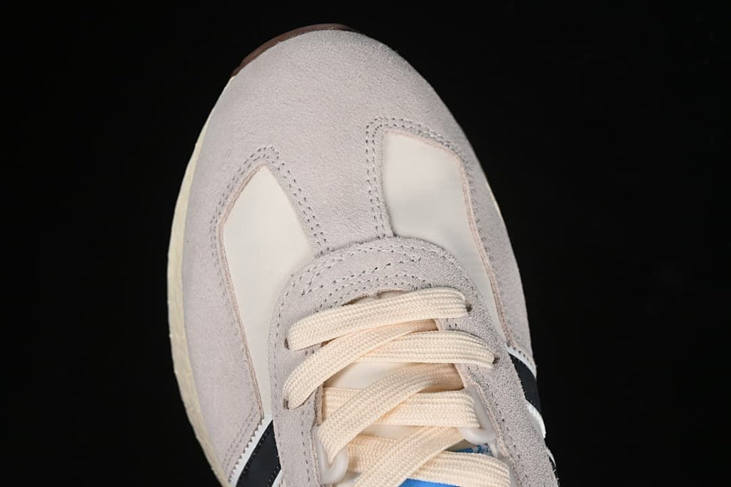 Top-down detail of the sneaker toe and cream laces.