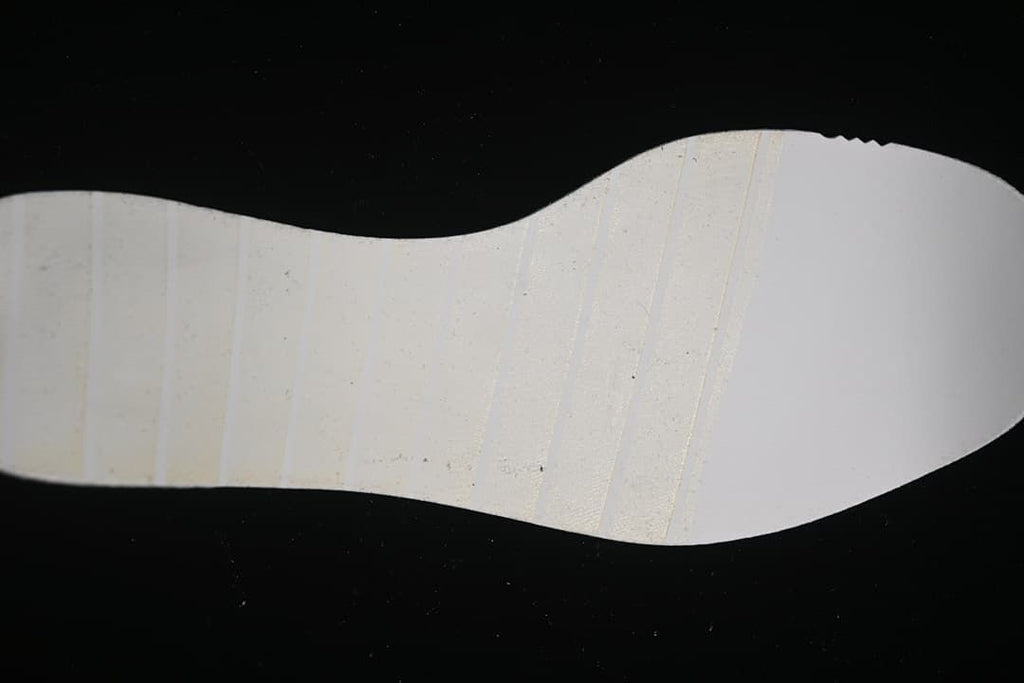 Close view of the light-colored outsole of the running shoe.