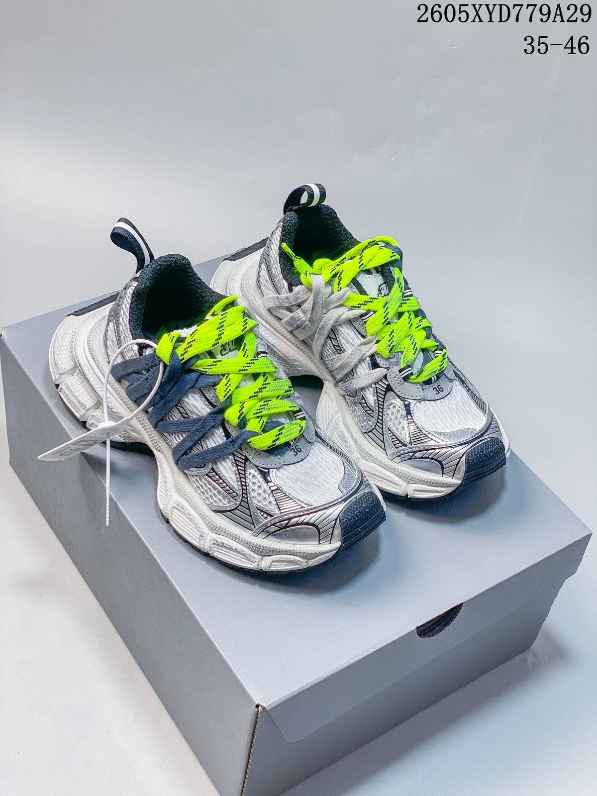 Silver and white Balenciaga Phantom sneakers with neon-yellow and dark blue laces.