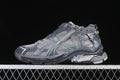 Side profile of a grey Balenciaga Runner-style sneaker against a dark background