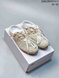Pair of cream Alo lace-up sneakers displayed on a white box