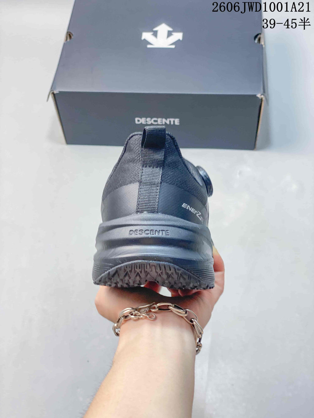 Rear view showing the heel construction and outsole tread of a dark gray DESCENTE sneaker