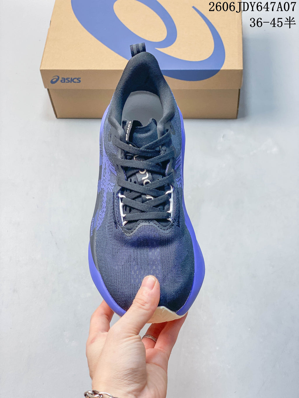 Top view of a navy running shoe with purple accents and laces
