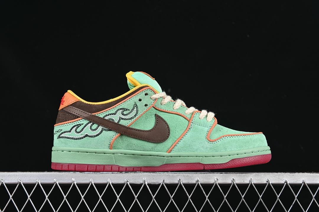 Side profile of the sneaker with mint green panels, embroidered graphics, and a red outsole.