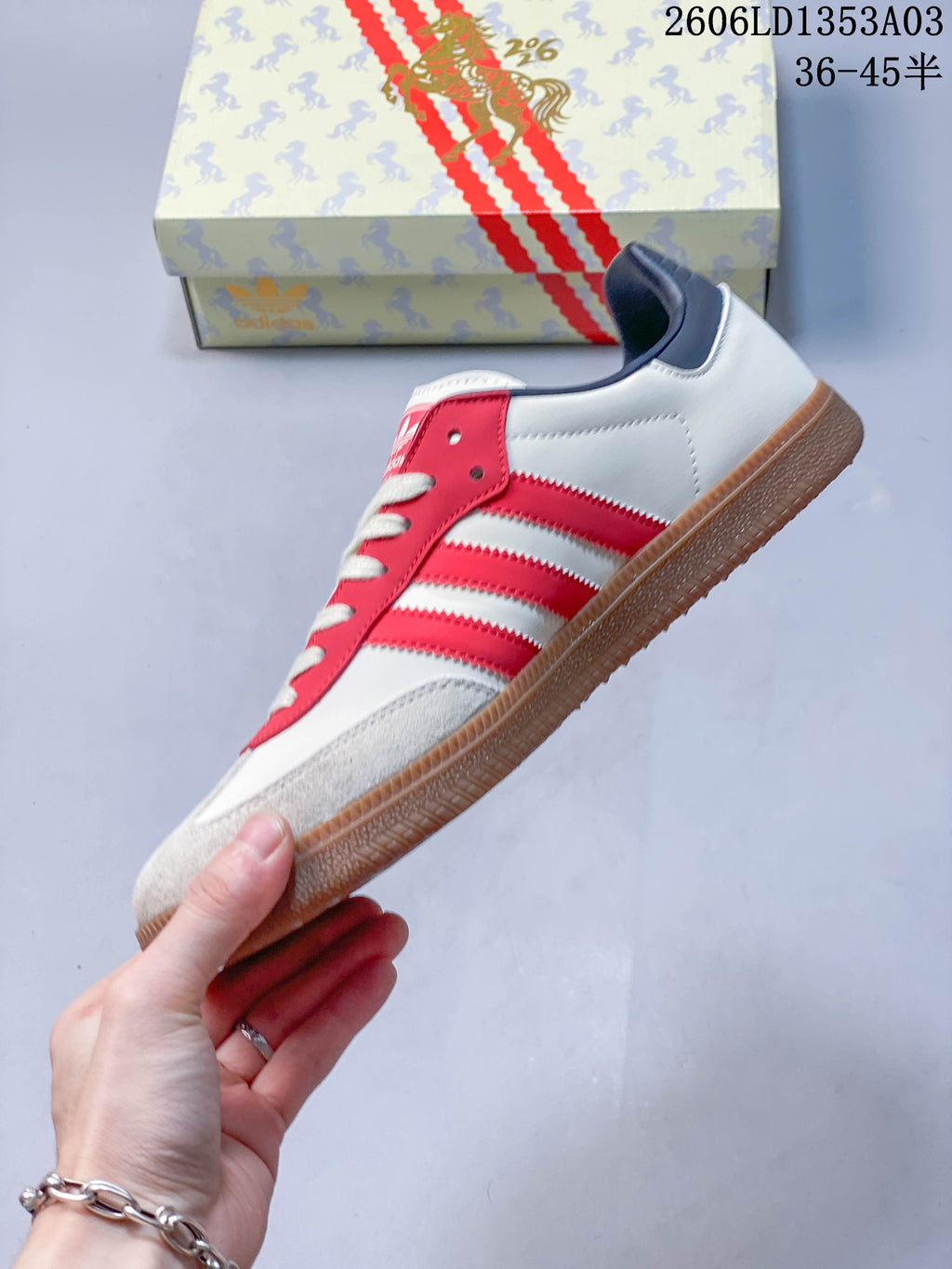 Side view of the white sneaker with red stripes and gum-colored outsole