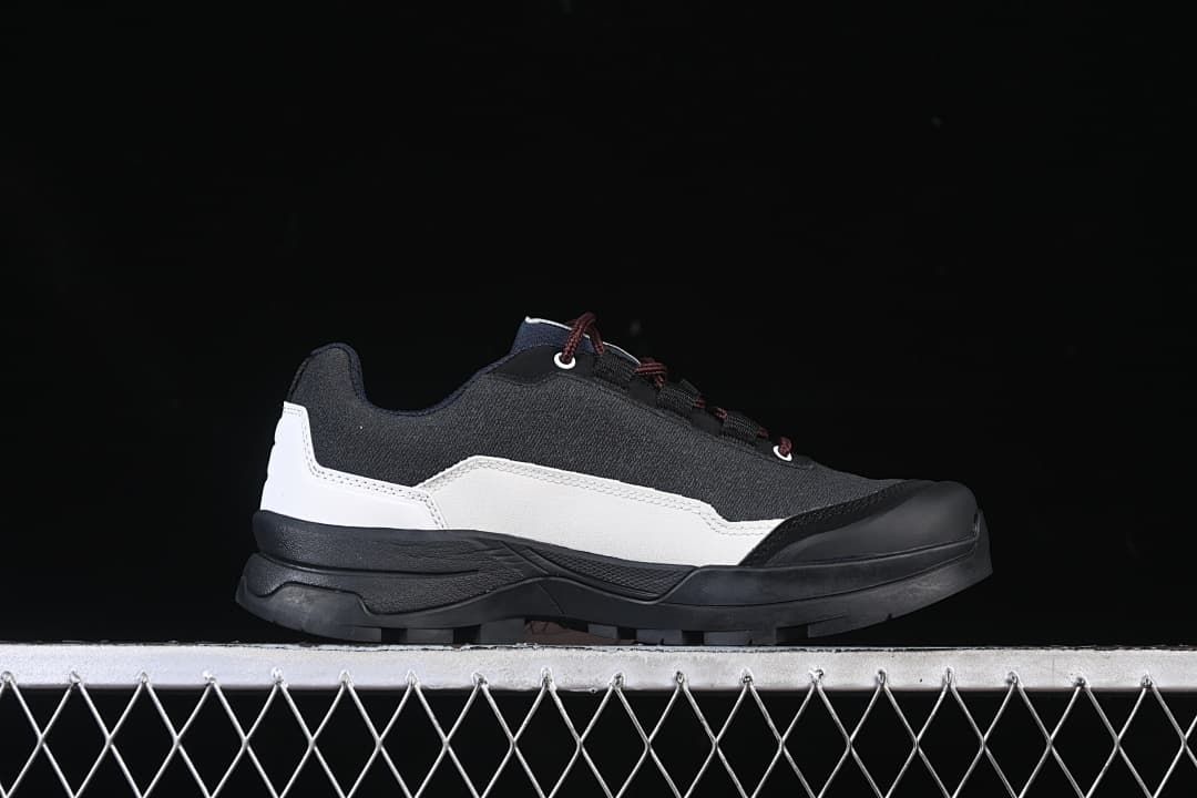 Side profile of the black and white Salomon outdoor shoe.