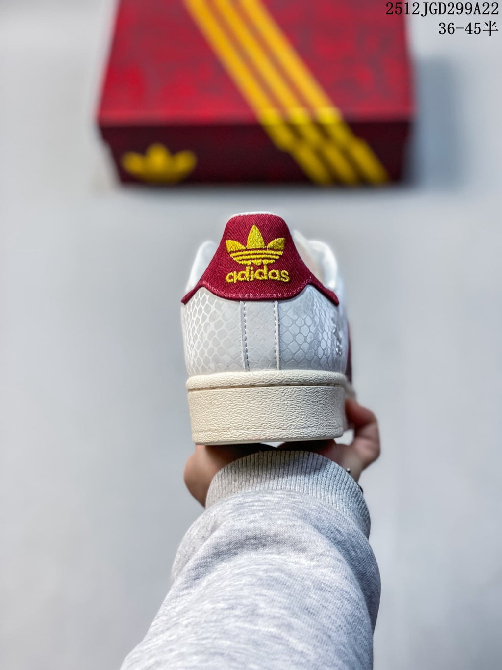 Rear view showing the red heel tab and textured white upper of an Adidas Superstar sneaker