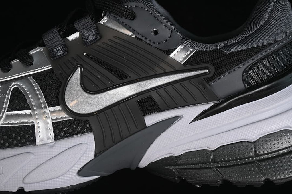 Close-up of the side Swoosh and layered black, silver, and white panels