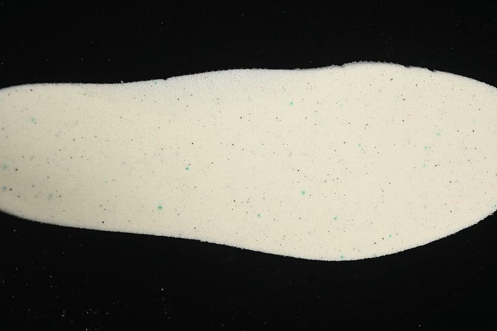 Light-colored shoe insole shown against a dark background.