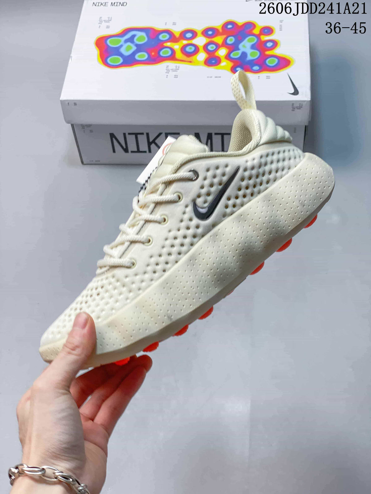 Side view showing the perforated upper and sculpted sole of a cream Nike Mind sneaker