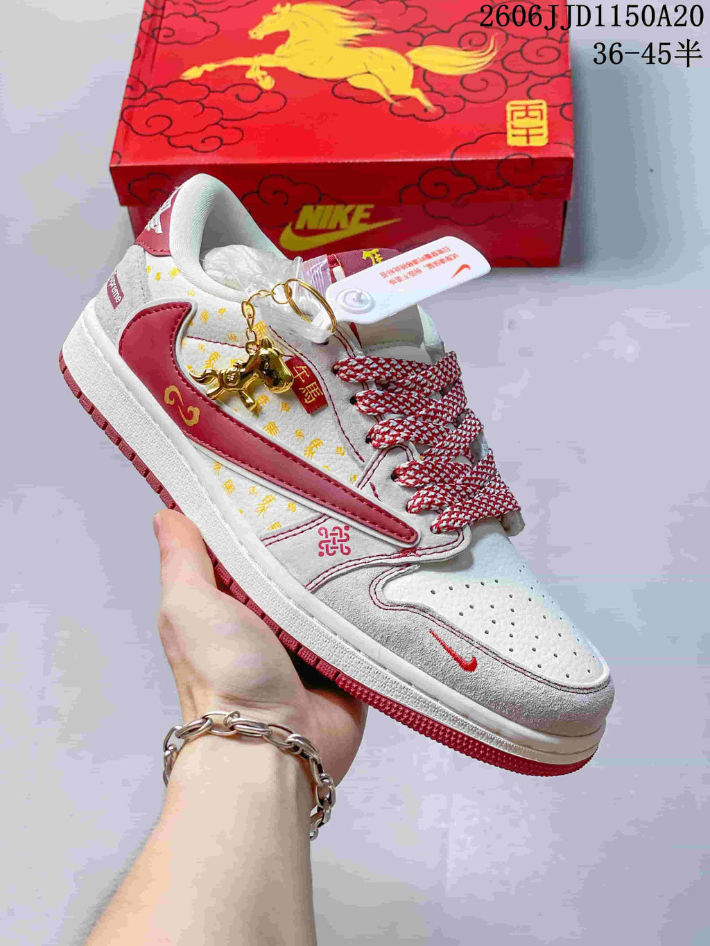 Close view of a white and burgundy low-top sneaker with printed details and a contrasting side panel.