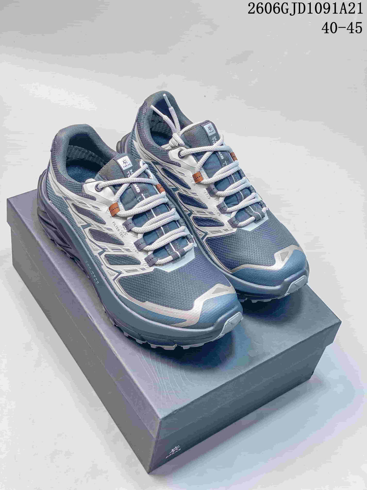 Pair of blue-gray Kailas trail running shoes with light overlays and lugged soles, shown on a shoe box