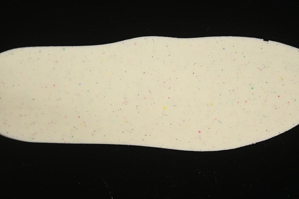 Close-up of a cream-colored sneaker insole with multicolored speckles