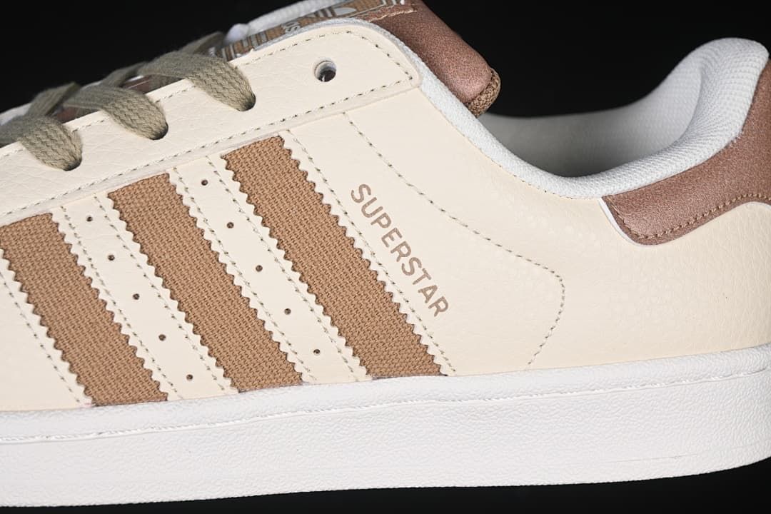 Close-up of the cream side panel, brown stripes, and Superstar lettering.