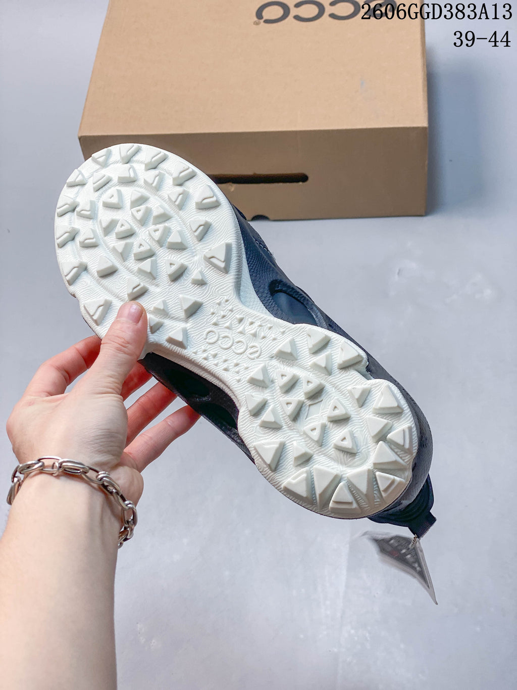 Close-up of the sneaker's light-colored outsole with raised geometric tread.